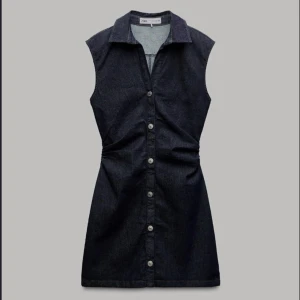 Zara blå klänning, storlek xs - En snygg och stilren klänning i denim med knappar framtill och en dragkedja i ryggen. Klänningen har en figursydd passform och är perfekt för både vardag och fest. Oanvänd. Nypris 399kr