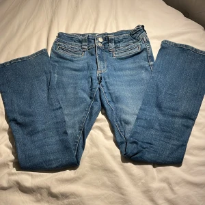 Lågmidajde utsvängda jeans! - Ett par lågmidajde utsvängda jeans som min syster växt ur. En absolut favorit! Lite snygga detaljer på ena benet. 📍Storlek: 158. Pris kan självklart diskuteras, och kontakta mig för flera bilder 💗