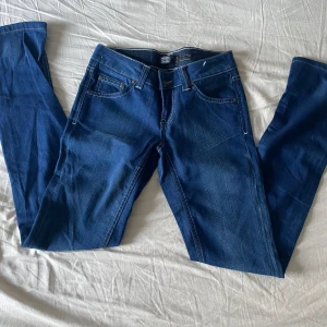 Blå jeans från ONLY - Säljer ett par snygga blå jeans från ONLY i storlek W26 L32. De är i bra skick och har en klassisk femficksdesign med dragkedja och knapp framtill. Perfekta för vardagsbruk och kan matchas med nästan vad som helst. Passa på att fynda dessa stilrena jeans!