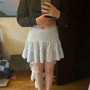 Blå volang kjol - Säljer min blåa volang kjol med vita blommor på från lager 157. Tror den inte säljs längre, är i mycket bra skick och inte speciellt mycket använd de senaste 2 åren. Inte trasig på nått sätt💞 Kontakta mig innan köp eller vid frågor🫶🏻