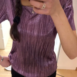 Glansig topp - Jättecool topp, i ett glansigt material. Fint skick och knappt använd. Storlek 170, men passar mig som brukar ha XS/S!