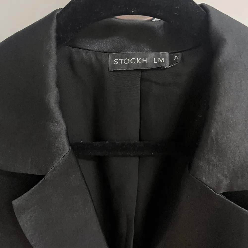 Svart elegant skjortklänning från Stockholm LM.  knälång. Har knappar och skärp samt fina detaljer. Använd 1 gång - som ny . Klänningar.