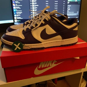 Nike Dunk Low Championship Court Purple - Säljer mina Nike Dunks i storlek 46. Är köpta på Stockx i september. Har haft på mig dom i max en vecka. Skriv för frågor och bilder!