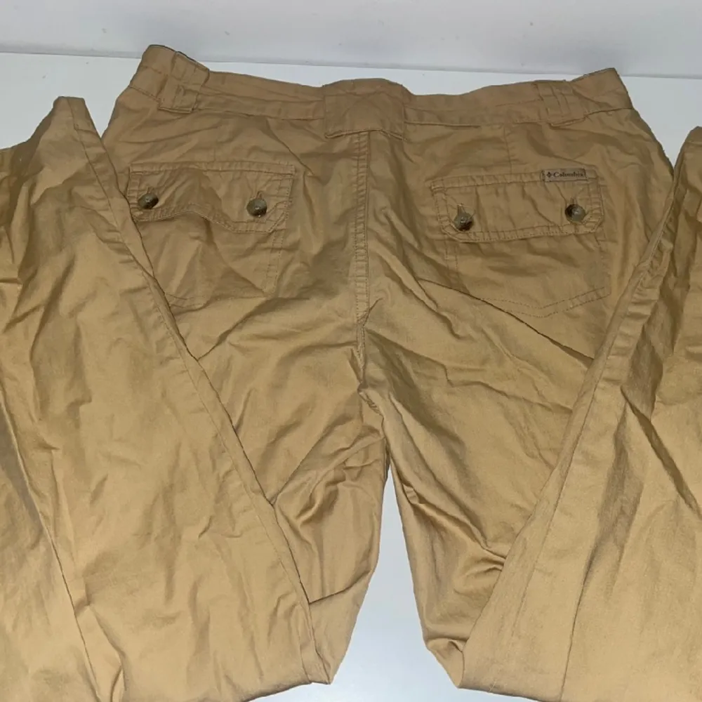 Ett par cargo byxor från Columbia sportswear, midjemåttet är 40 cm tvärs över skulle säga att dem är mid/high rise. . Jeans & Byxor.
