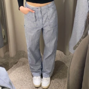 Hm randiga cargo byxor - Blå Vita randiga cargo byxor från HM. Del av set.Aldrig använda då de är lite för stora i midjan. Storlek 36. 