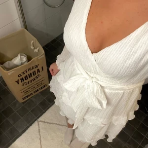 Vit studentklänning / skolavslutning - Vit klänning, köpt från Dennis Maglic, size S!  Aldrig använd, men superfin med volanger och glittrar, samt har knytband i midjan!! Finns inte kvar på sidan, men har kvar kvitto, nypris är 600! Säljer för 450!  Har fler bilder! Samt har den underkjol