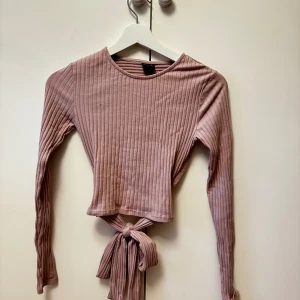 Långärmad tröja med knyte bak - Fin långärmad tröja med knyte bak i ryggen, använd fåtalet gånger och är i en fin ljuslila färg💕 färgen visas bäst på första bilden! Storlek xs, hör av dig vid frågor!