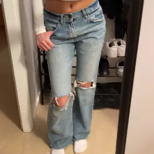 Midwaist flared jeans med hål i storlek 34