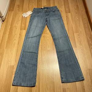 (34) lågmidjade bootcut jeans med specialfickor helt nya med lappar kvar. Stretch så passar större än måtten, glittriga fickor och sömmar. Innerbenslängd: 80cm, midjemått rakt över: 33 cm 🩵