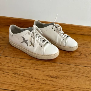 Säljer äkta Arigato sneakers - Jag säljer äkta Arigato vita sneakers, perfekt till vardag men även till festligare tillställningar, passar till allt. Storlek 40, små i storleken. Använda men i gott skick.