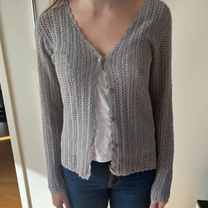 Kofta - Här säljer vi en super fin kofta i en grå silvrig färg! Den är lite glittrig också. Perfekt till alla olika årstider! Storleken är 38/40 men passar mer än S och M 