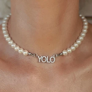YOLO (you only live once) halsband med imiterade pärlor - YOLO (you only live once) halsband med imiterade pärlor Material: Imiterade pärlor och rostfritt stål! Helt ny! Storlek:42 cm(justerbar)