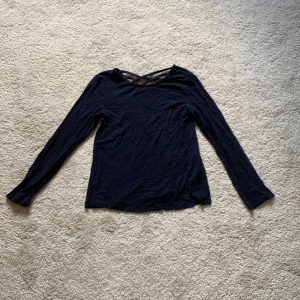 Skitsnygg marinblå tröja med fin rygg!! - En långärmad tröja med fin rygg. Passar någon mindre med storleken 134-140.