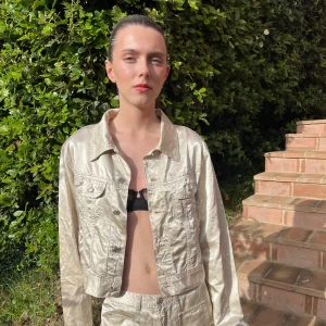 Gold Jacket - A lovely jacket with a white gold material and silver button details 💛 Style with some denim shorts or the matching trousers for a timeless look!  Get the full set for 400kr!  length : 48 cm  bottom width: 88cm  chest: 104cm  