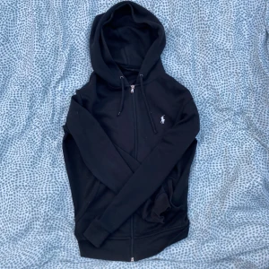 Polo zip up - Säljer min svarta populära polo zip-up. Säljs då den inte riktigt kommer till användning längre. Använd väldigt få gånger, vilket märks på skicket! Om du har minsta lilla fråga eller vill ha mer bilder är det bara att höra av dig. Mvh