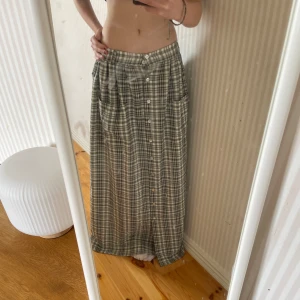 Rutig kjol - En rutig långkjol från Daniéls i storlek L. Jag har tidiga bärt den med ett bälte och det funkar jättebra. Den har knappar hela vägen ned, så om man knäpper upp dom kan man ha ett ”slit” i mitten! Jag är 162 cm för referens.