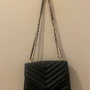 Svart väska - Den är i bra skick men har lösa trådar på sidan 