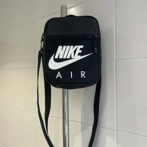 Nike väska  - Otroligt cool väska från Nike. Använd några fåtal gånger då det inte är min stil längre. Den är justerbar med många fack, dragkedjor och mycket utrymme!