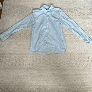 Ljusblå Gant Skjorta - Snygg ljusblå gant skjorta som är nästan oanvänd. Skick 10/10. Passar folk som är runt 156-166 cm långa. Skjortan stryks vid köp.
