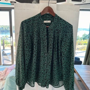 Vlus - En grön leopard blus från Mango