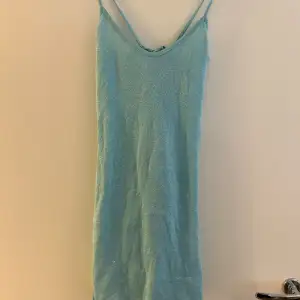 Kort, glittrig klänning från NA-KD med knytning i ryggen. Fint skick