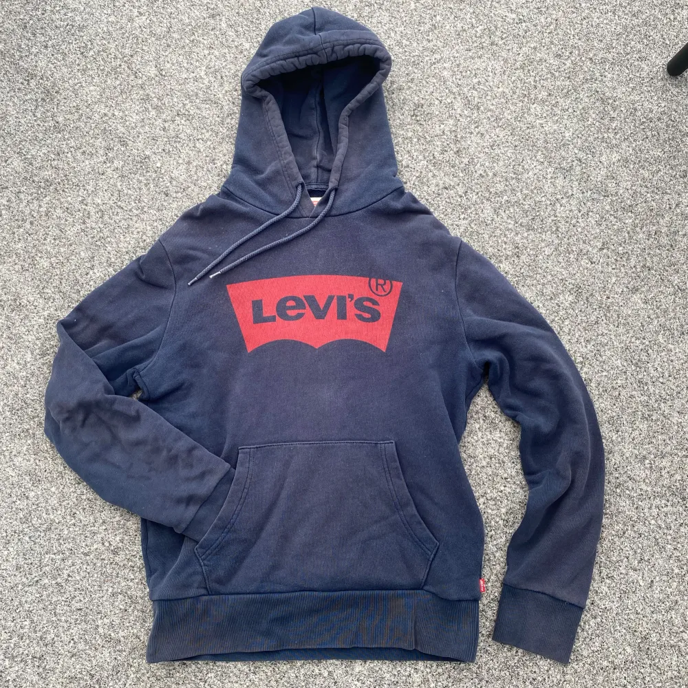 Säljer en mörkblå hoodie med snören från Levis🤩Den har deras märke tryckt i rött på framsidan!! Kan passa tejer & killar🙌🏻Strl. S. I bra använt skick, (lite sliten/tappat färgen någonstans & pyttelite nopprig nånstans). Billiga kläder➡️min profil😚. Hoodies.