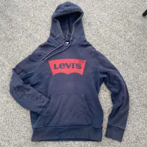 Säljer en mörkblå hoodie med snören från Levis🤩Den har deras märke tryckt i rött på framsidan!! Kan passa tejer & killar🙌🏻Strl. S. I bra använt skick, (lite sliten/tappat färgen någonstans & pyttelite nopprig nånstans). Billiga kläder➡️min profil😚