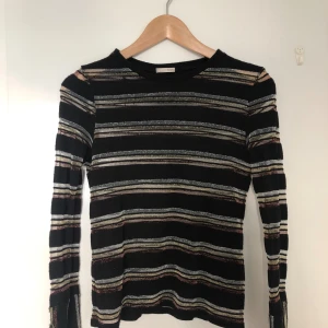 Glittrig långärmad ZARA - Glittrig långärmad topp från ZARA. Lite slitage längst ned i ärmen och ett hål i höger axel (se bild).