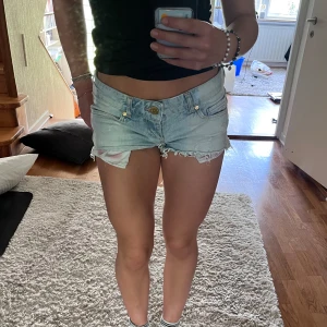 Lågmidjade shorts - Ett par lågmidjade jeansshorts med rosa detaljer på sidan. Midjemått är 38 cm tvärs över💞