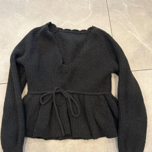 Svart stickad tröja med knytning - I mycket bra skick