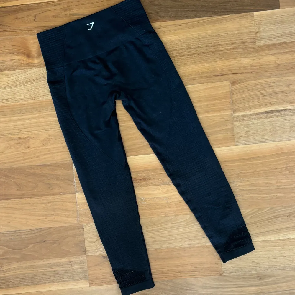 Gymsharktights med cut-out detaljer på båda anklarna (fram samt baksida) som är lite slitna vid full utstreckning (har aldrig synts för mig). Bortklippt tvättlapp då den skaver vid användning. Ribbad textur och plagget är lite större i storleken. :). Sportswear.