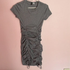 Grå ribbad justerbar klänning - En grå klänning som man kan själv justera med vilja. Ribbad och inte för kort.