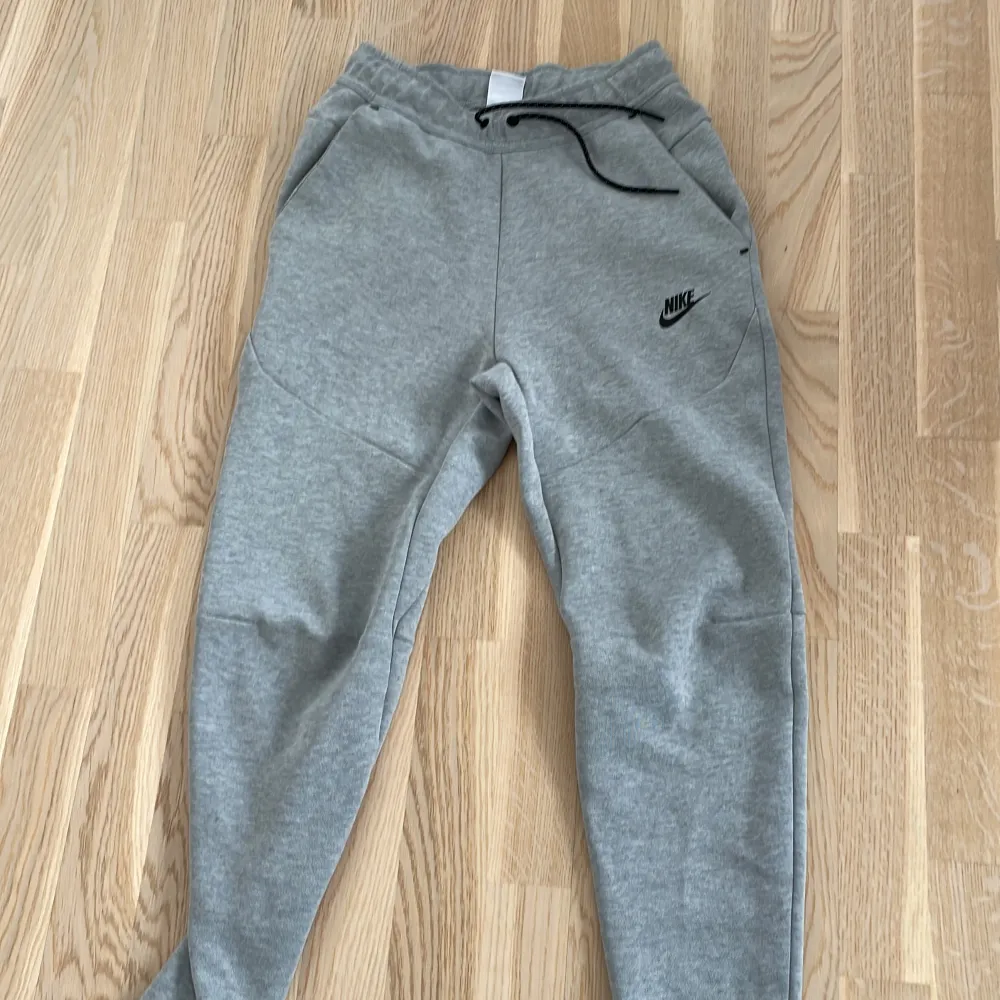 Gråa Nike tech byxor stl XS finns matchande tröja i samma stl köp byxorna/tröjan för 800 var och en för 500kr var.. Jeans & Byxor.
