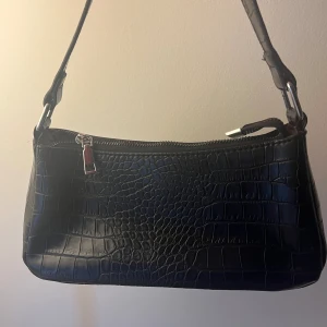 Svart axelväska med krokodil mönster - En classy svart axelväska med krokodil mönster på🖤 har inga defekter och ser helt ny ut:)