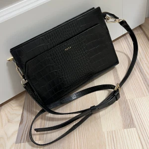Väska - Svart crossbody väska ifrån Wera modell Pinza. Äkta skinn.  Ytterfack samt innerfack. Lite sliten på dragkedjan, se bild 3. Annars bra skick! 