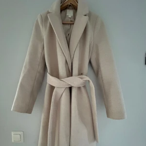 Fin vit/beige HM kappa 🤍 - Säljer denna kappan från HM 🤍 Använd vintern 2022 och har sedan dess hängt på en krok. Ganska lång på mig (161cm) och passar XS/S/M. Skriv om du vill ha fler bilder! 🥰