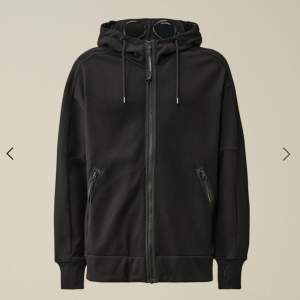 Säljer nu en helt oanvänd svart C.P Company zip hoodie. Fler bilder finns!Skriv gärna vid funderingar.  Nypris 3200kr Storlek M