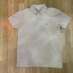 Krämvit Lacoste pikétröja  - Ny schysst Lacoste pikétröja i krämvit storlek M