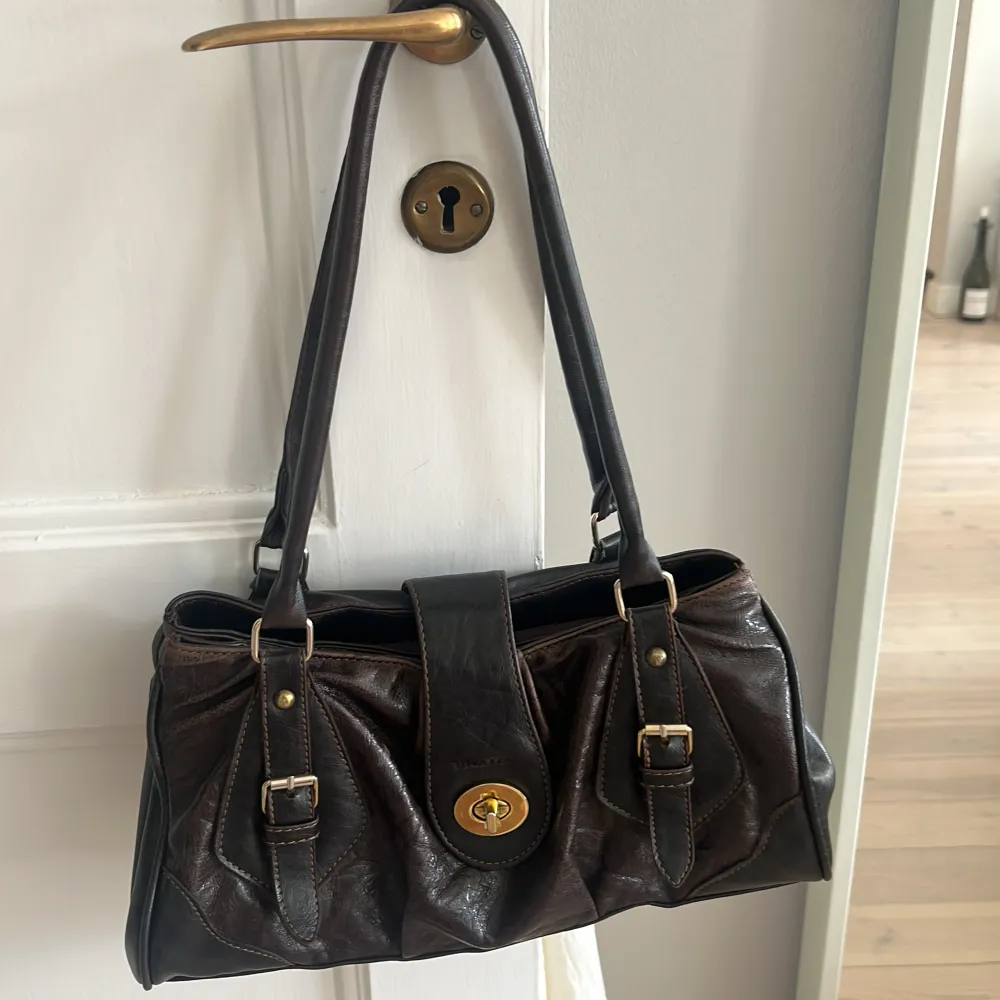 Snygg brun väska med guldiga detaljer. perfekt storlek å så snygg! . Väskor.