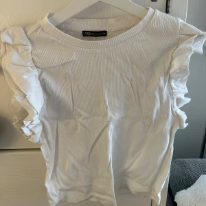 Vitt volangtopp ifrån zara - Storlek: L (väldigt liten i storleken)