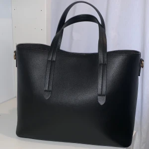 Svart väska - Stor svart väska perfekt för skolan eller jobbet. Kommer med en längre axelhäng. I god skick