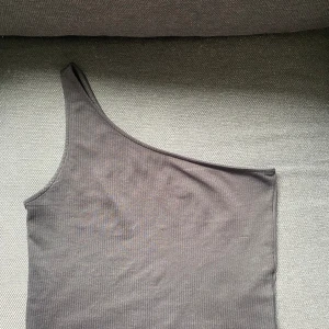 Svart topp med ett axelband - Använd fåtal gånger, svart topp i storlek m