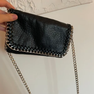 Väska med kedja  - Väska från tiamo med kedja. Använd fåtal gånger och är som ny 