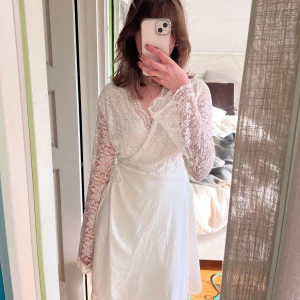 Studentklänning  - Vit omlottklänning i spets, perfekt för studenten, midsommar eller liknande💕 Säljer pga hittat annan klänning, jättefin och justerbar storlek men passar nog generellt xs-m