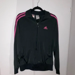Adidas zip - Mörkgrå kofta med rosa streck. Står på lappen att den är XL men jag håller inte med. Jag skulle säga att den är en M. Jag som är S kan ha den, då är den pösig. På någon som har XL skulle den vara tight.Kan skicka bild med den på!❤️kontakta för frågor!