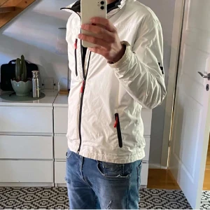 Helly Hansen Jacka - Galet snygg Helly Hansen windbreaker jacka. Passar perfekt till sommarkvällar och kyligare dagar. Skick 8/10. Storlek S. Tveka  inte att skriva om ni undrar något eller vill ha fler bilder. Kan mötas upp Stockholm & även skicka.