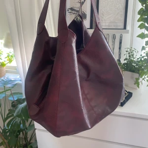 Röd väska - Vintage röd väska, väldigt praktisk, två fack med knapp och ett rymligt fack med dragkedja i mitten!