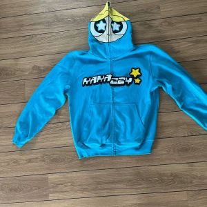 Kakazzy zip - Kakazzy zip i storlek M. Använd fåtal gånger så den är i fint skick förutom två små hål på luvan.