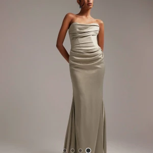 Bal eller brudtärne klänning - Köpte denna klänning i både storlek 34 och 38 (slutsåld sen länge). Den i storlek 38 har aldrig blivit använd. Den är beige med ett vackert grönt skimmer. Kontakta mig för fler bilder på hur den sitter på eller andra frågor. 💗