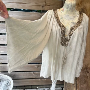 Härlig ”hippie” blus med vida ärmar - Luftig tunn bomull med paljetter och band upptill. Vida 3/4 ärmar. Onesize och oversize upp till stl XL. Inte mycket använd i fint skick.